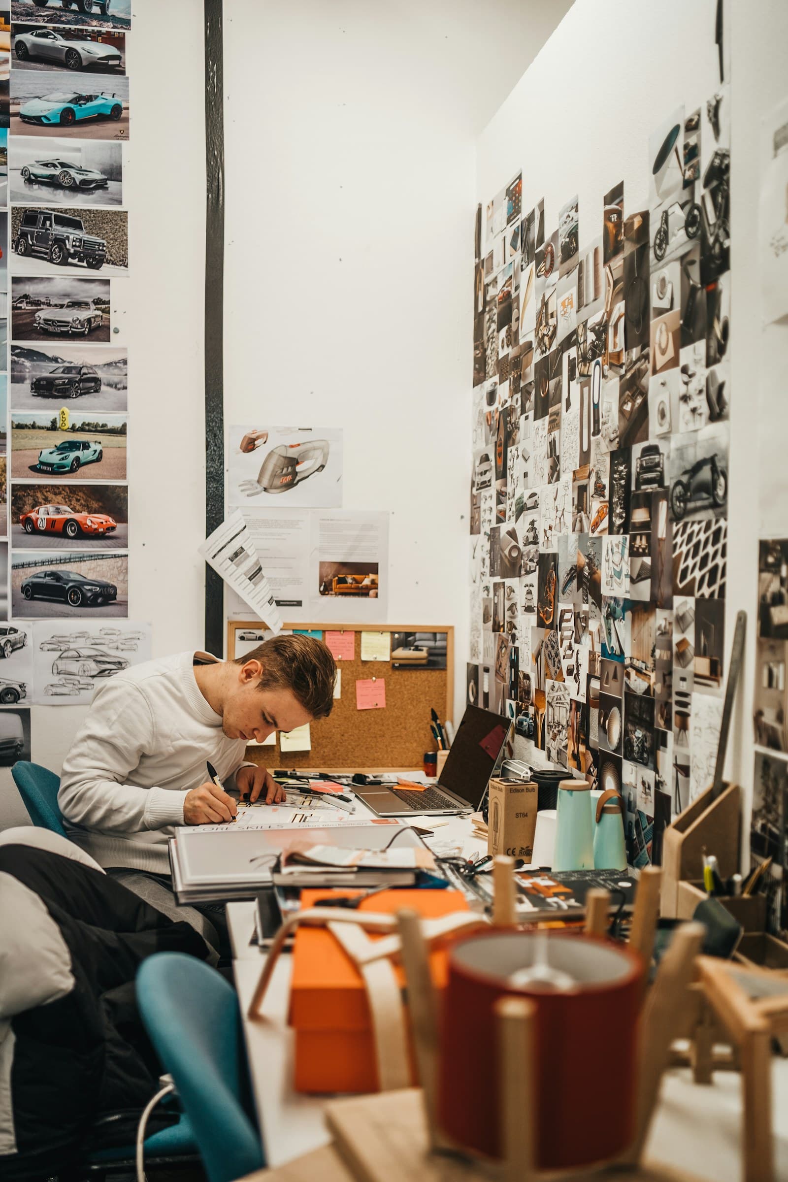 Un designer travaille au milieu de croquis et d’un tableau d’inspiration