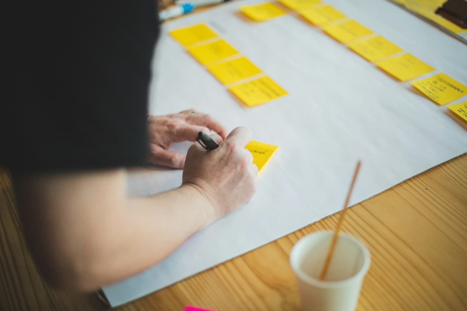 Een teamlid werkt een plan uit met notities en pen